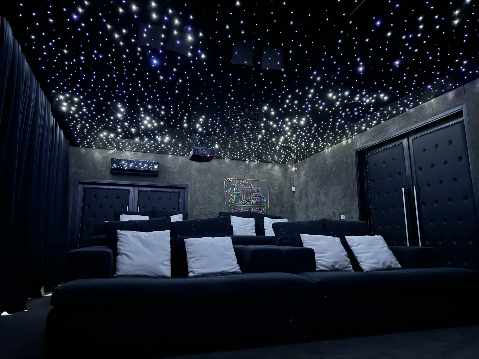 Sala con sofás y cielorraso con una trama densa de estrellas